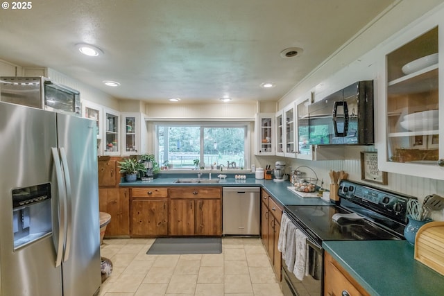 11885 Riverhaven Ln SE, Stayton, OR 97383 - kitchen with black appliances, brown cabinetry, a sink, dark countertops, and recessed lighting