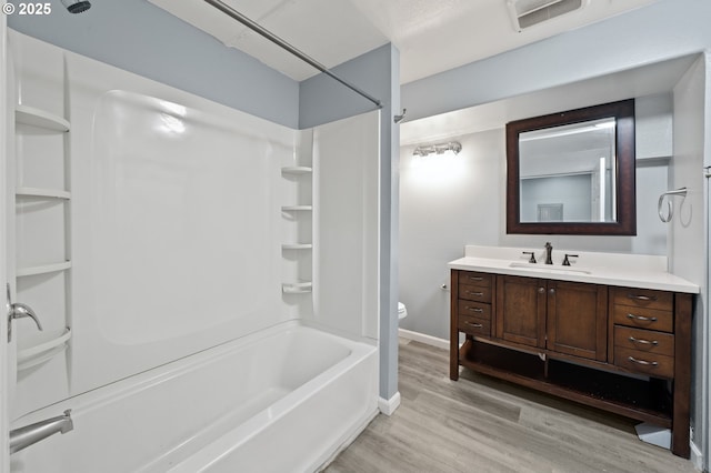 3541 SW Wonderview Ave, Gresham, OR 97080 - bathroom with wood finished floors, toilet, vanity, washtub / shower combination, and baseboards