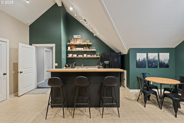 20015 NE 234th St, Battle Ground, WA 98604 - indoor wet bar with track lighting, baseboards, black fridge, and high vaulted ceiling