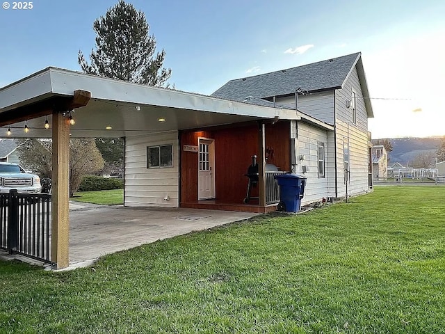 back of house featuring a yard and an attached carport