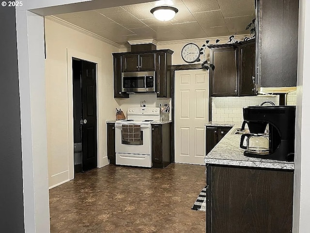 kitchen featuring crown molding, dark brown cabinets, white range with electric cooktop, stainless steel microwave, and baseboards