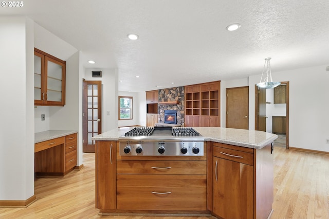 1324 Stonehaven Dr, West Linn, OR 97068 - kitchen with stainless steel gas cooktop, light wood-style floors, brown cabinetry, baseboards, and recessed lighting