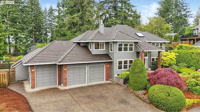 1324 Stonehaven Dr, West Linn, OR 97068 - view of front of house featuring brick siding, a chimney, driveway, a garage, and a tiled roof