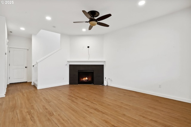 unfurnished living room featuring ceiling fan and light hardwood / wood-style flooring