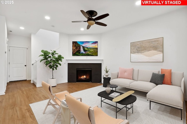 living room with light hardwood / wood-style flooring and ceiling fan