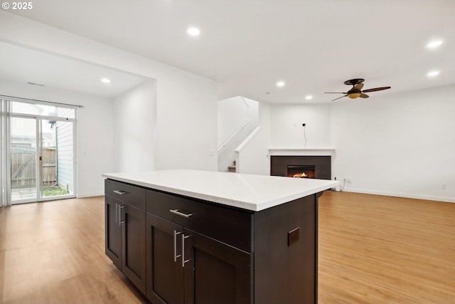 kitchen with ceiling fan, light hardwood / wood-style flooring, and a kitchen island