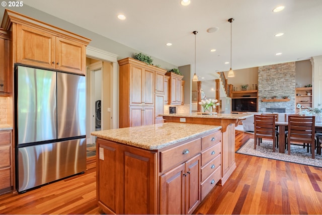 21106 NW 3rd Ct, Ridgefield, WA 98642 - kitchen with stainless steel refrigerator, a center island, light wood-type flooring, decorative backsplash, and recessed lighting