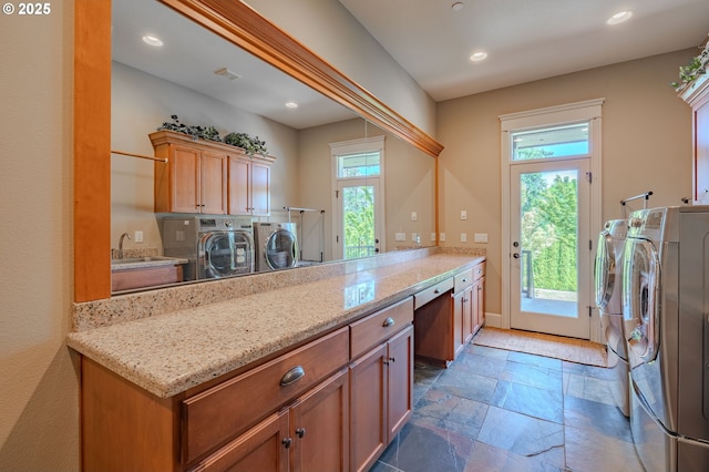 21106 NW 3rd Ct, Ridgefield, WA 98642 - laundry room featuring washer and dryer, stone tile flooring, cabinet space, plenty of natural light, and recessed lighting