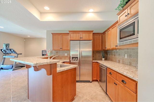 21106 NW 3rd Ct, Ridgefield, WA 98642 - kitchen with stainless steel appliances, backsplash, light tile patterned floors, a breakfast bar area, and recessed lighting
