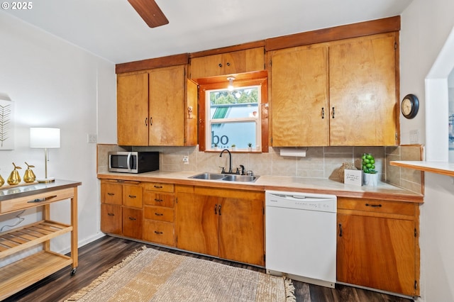 kitchen featuring white dishwasher, decorative backsplash, dark hardwood / wood-style flooring, and sink