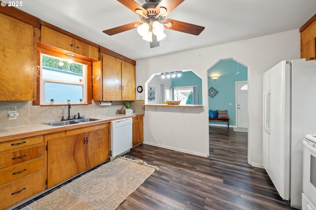 kitchen featuring white appliances, dark wood-type flooring, sink, ceiling fan, and decorative backsplash