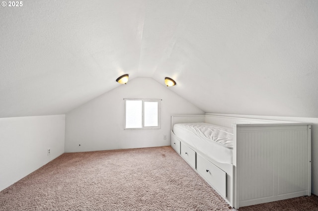 unfurnished bedroom with carpet and vaulted ceiling