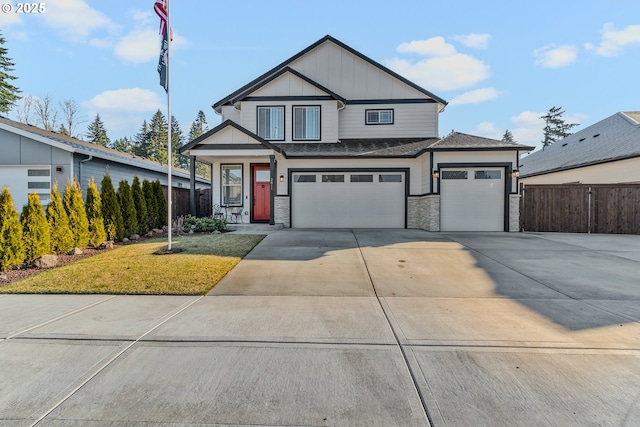 view of front of property with covered porch, fence, concrete driveway, board and batten siding, and a front yard