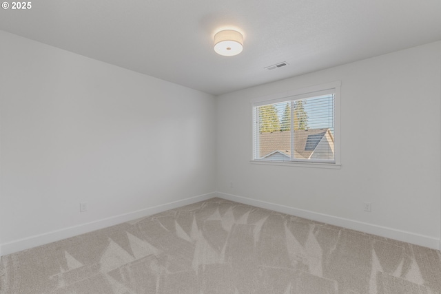 carpeted spare room featuring visible vents and baseboards