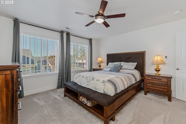 bedroom with baseboards, visible vents, ceiling fan, and light colored carpet