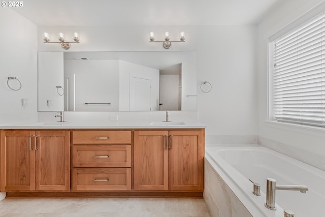 bathroom with double vanity, a sink, and a bath