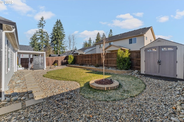 view of yard with an outbuilding, a fenced backyard, an outdoor fire pit, and a storage shed