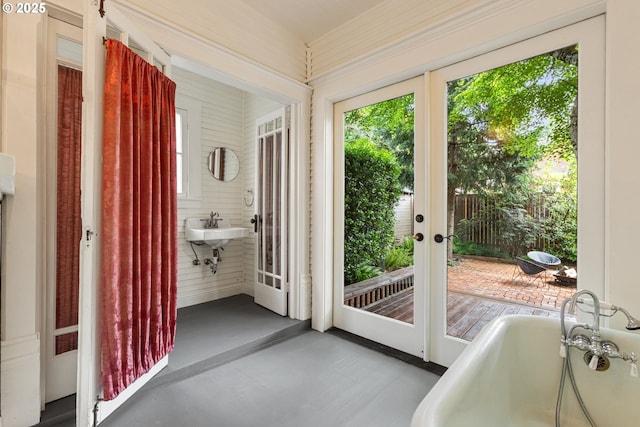 doorway to outside with a healthy amount of sunlight, french doors, concrete floors, and a sink