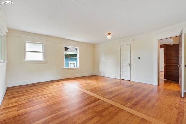 empty room featuring baseboards and light wood finished floors