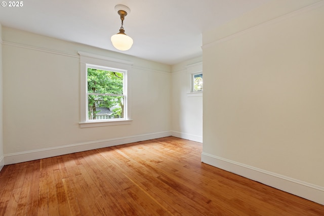 empty room featuring light wood-type flooring and baseboards