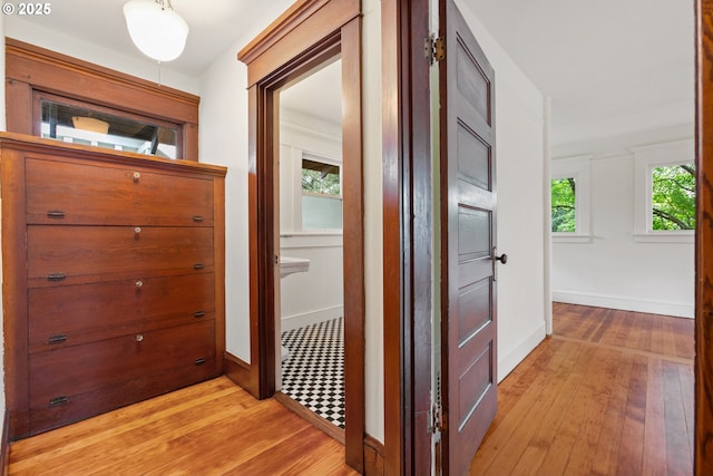 hall featuring baseboards and light wood-type flooring