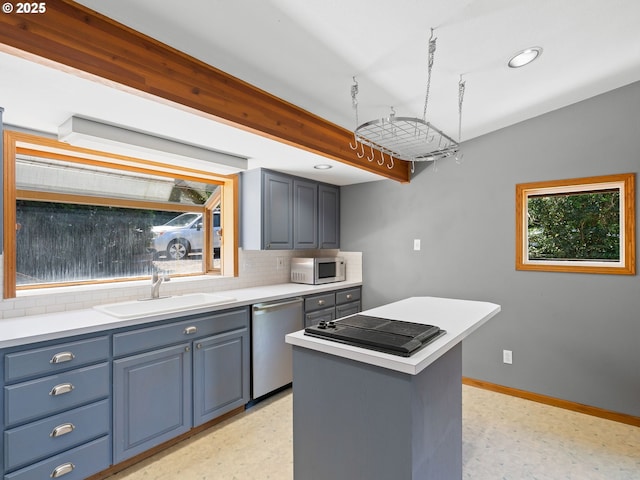6310 SW 35th Ave, Portland, OR 97221 - kitchen featuring appliances with stainless steel finishes, light countertops, a kitchen island, tasteful backsplash, and recessed lighting