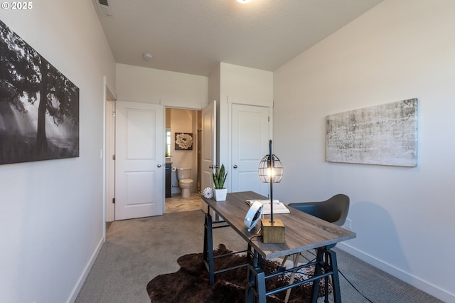 carpeted office with visible vents and baseboards