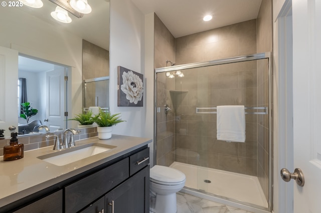 bathroom with marble finish floor, vanity, a shower stall, and toilet