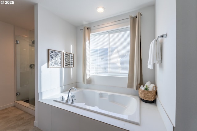 bathroom featuring a garden tub and a shower stall