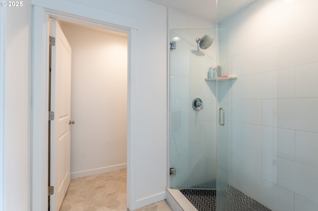 bathroom with a stall shower and baseboards