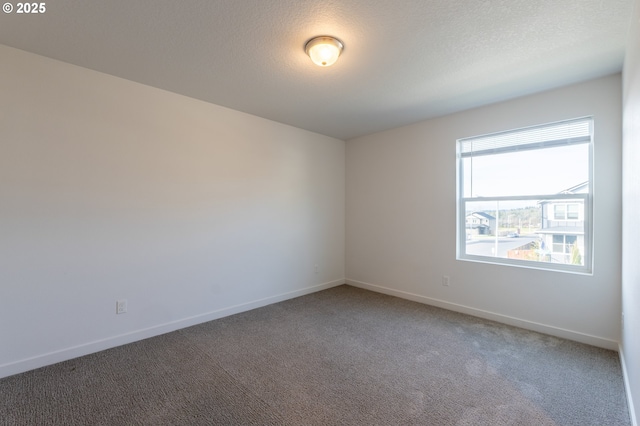 unfurnished room with carpet flooring, a textured ceiling, and baseboards