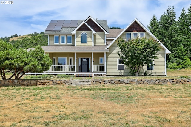 1317 Riggleman Ln, White Salmon, WA 98672 - view of front of property with covered porch, solar panels, a front yard, and roof with shingles