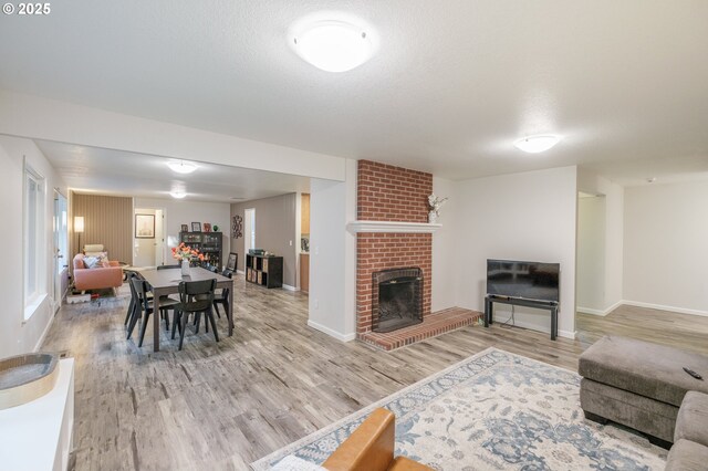 3727 NW Arrowood Cir, Corvallis, OR 97330 - living area featuring a fireplace, light wood-style floors, and baseboards
