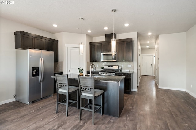 2360 N R St, Washougal, WA 98671 - kitchen featuring appliances with stainless steel finishes, dark wood-style floors, tasteful backsplash, a center island with sink, and recessed lighting