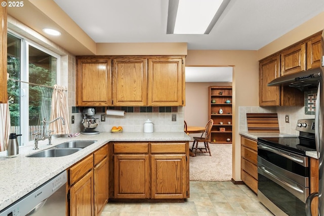 kitchen with a sink, decorative backsplash, under cabinet range hood, and stainless steel appliances