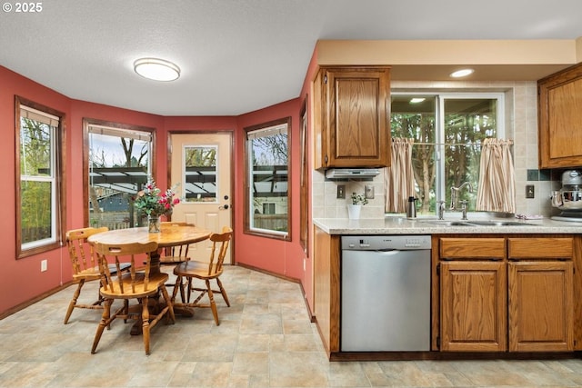 kitchen with a sink, tasteful backsplash, dishwasher, and brown cabinetry