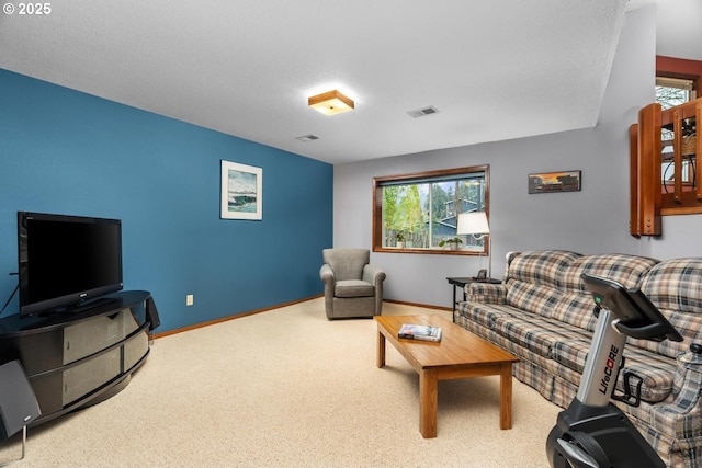 carpeted living room featuring a wealth of natural light, visible vents, baseboards, and a textured ceiling