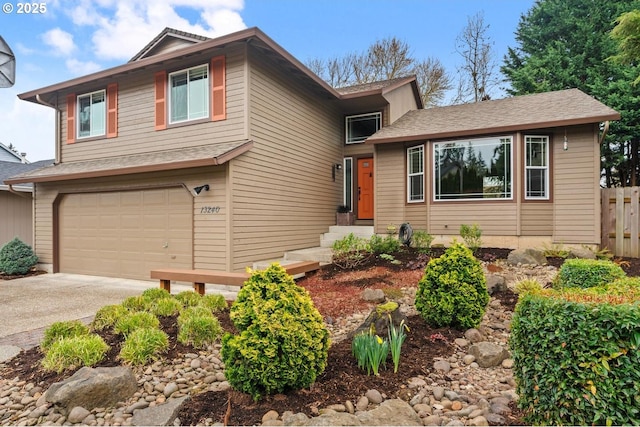 tri-level home with fence, a garage, and driveway