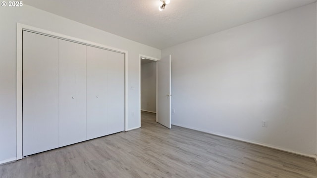151 E Date St, Powers, OR 97466 - unfurnished bedroom featuring wood finished floors, a closet, baseboards, and a textured ceiling
