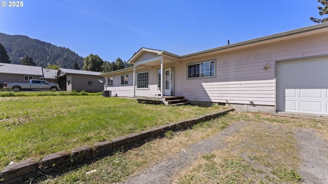 151 E Date St, Powers, OR 97466 - view of front of home featuring a mountain view, driveway, a front yard, crawl space, and central AC unit