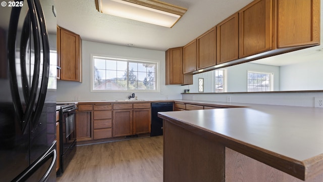 151 E Date St, Powers, OR 97466 - kitchen with black appliances, light wood-style flooring, healthy amount of natural light, and a sink