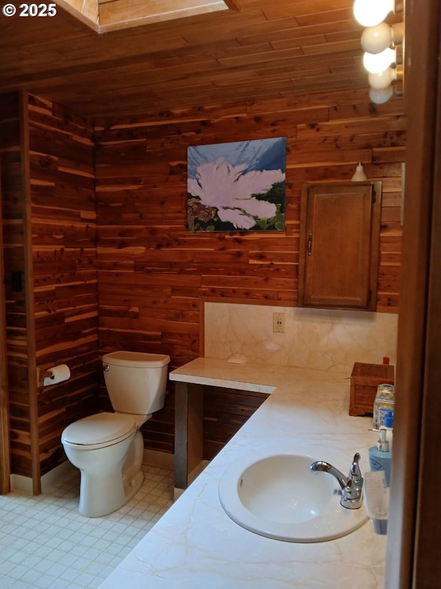 9655 8th St, Bay City, OR 97107 - half bath with wooden walls, wood ceiling, tile patterned floors, and vanity