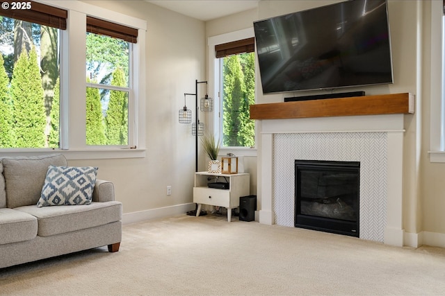 sitting room featuring a wealth of natural light, carpet flooring, and a tile fireplace