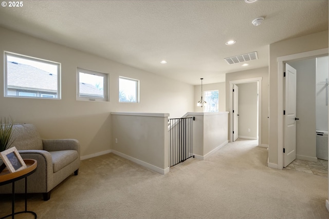 sitting room featuring light colored carpet, visible vents, baseboards, and recessed lighting