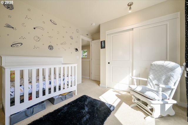 bedroom with light carpet, baseboards, and a closet