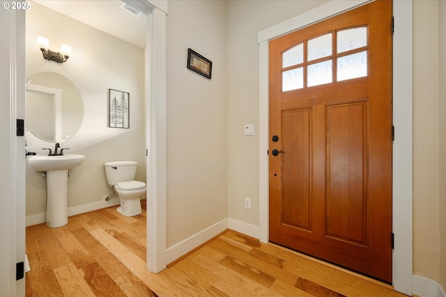 entrance foyer with baseboards, visible vents, and light wood finished floors