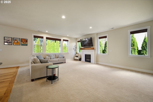 carpeted living area with visible vents, a wealth of natural light, and recessed lighting