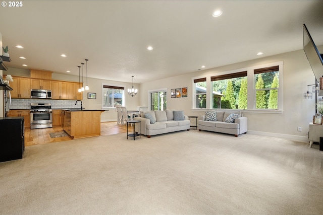 living room with light carpet, baseboards, a notable chandelier, and recessed lighting