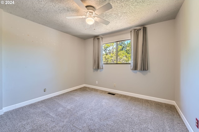 carpeted spare room featuring ceiling fan, a textured ceiling, visible vents, and baseboards