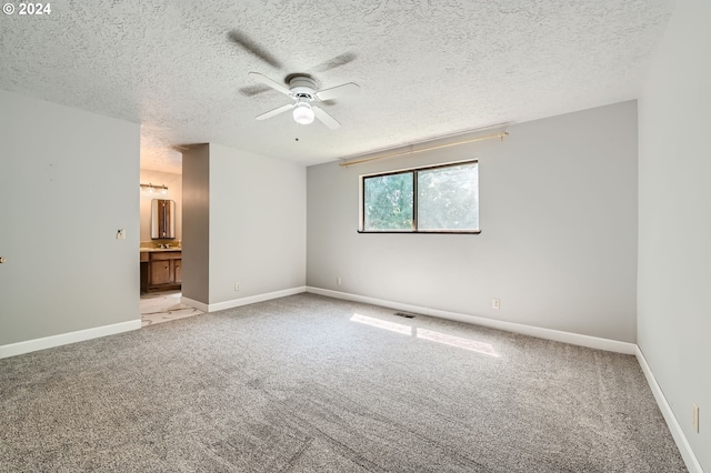 empty room with ceiling fan, light carpet, a textured ceiling, and visible vents